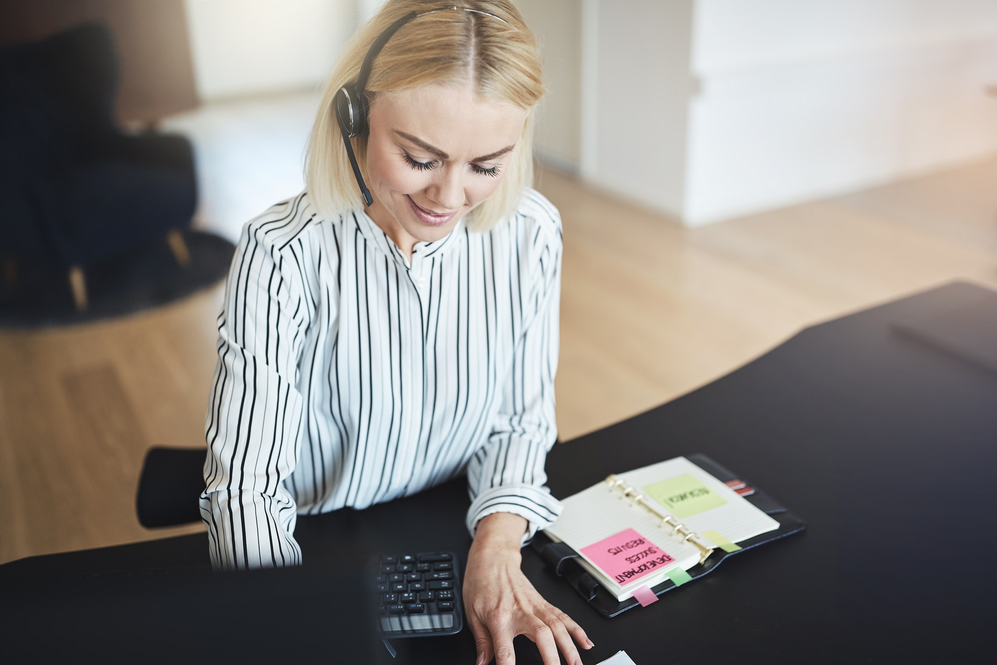 businesswoman-talking-with-her-client-on-a-headset-at-work